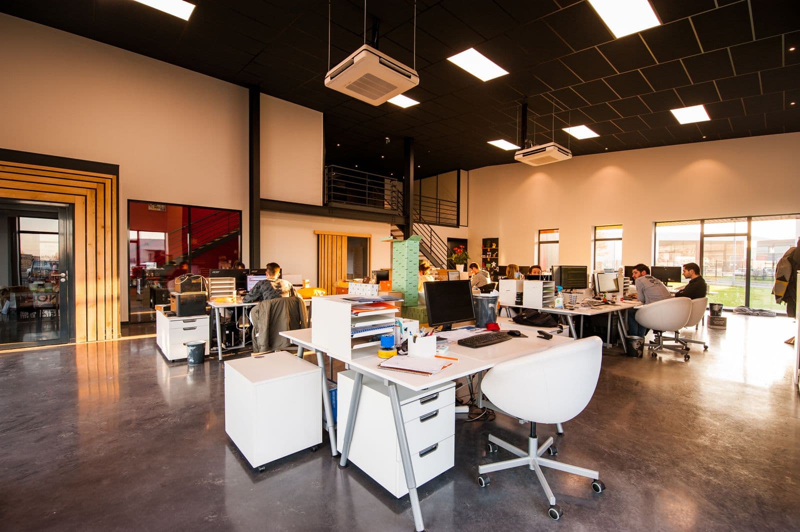 Espace de coworking moderne à Genève avec postes de travail et lumière naturelle